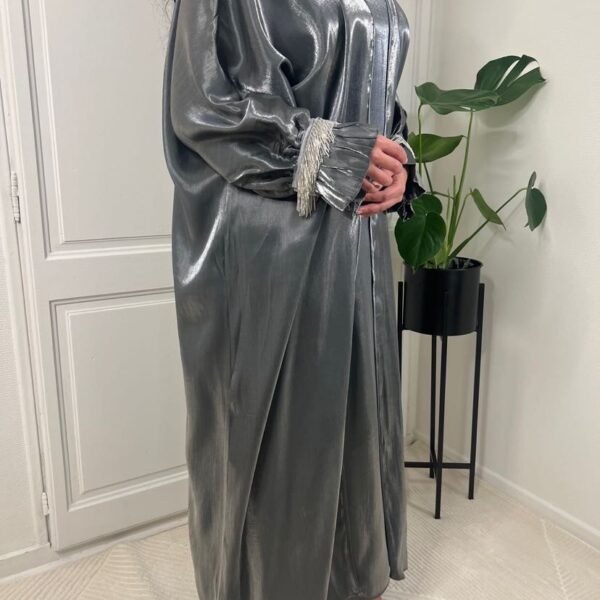 Photo prise de profil de l'abaya Basma en deux pièces et de couleur grise de chez Golden Boutique